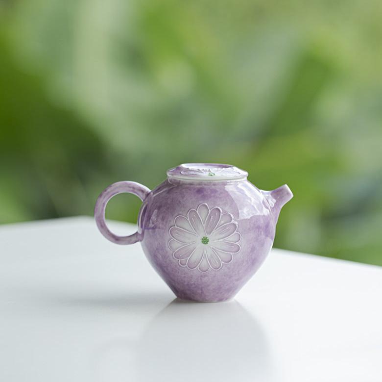 this is a purple ceramic teapot