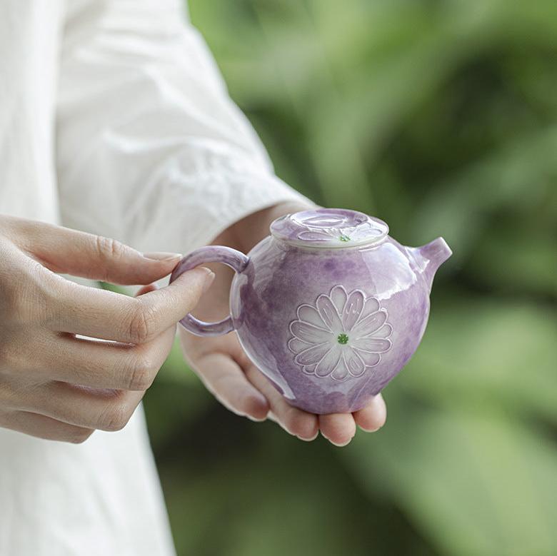 this is a purple ceramic teapot