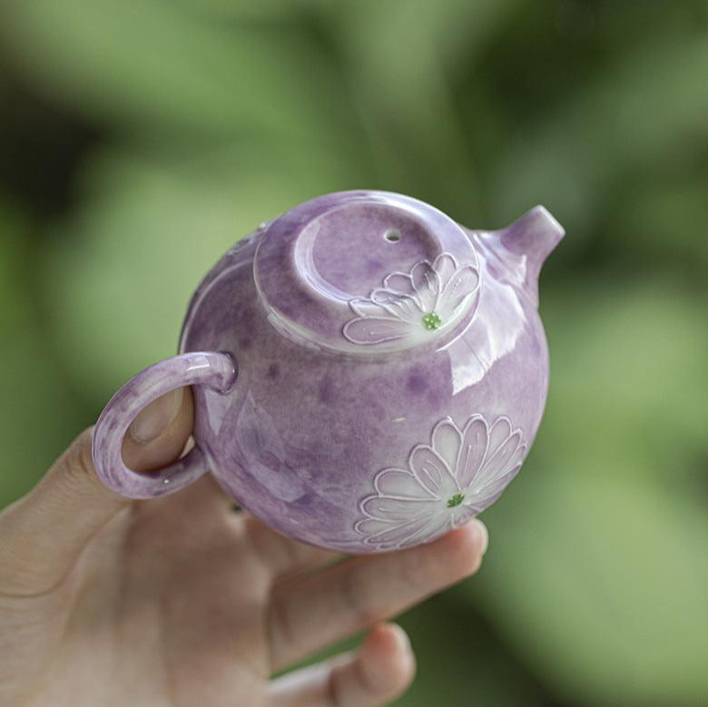 this is a purple ceramic teapot