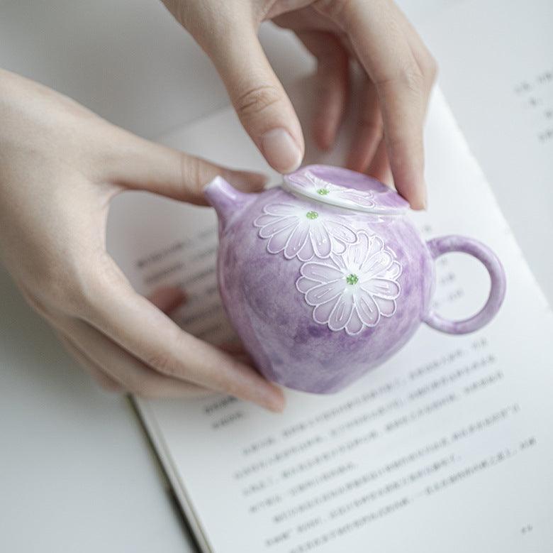 this is a purple ceramic teapot