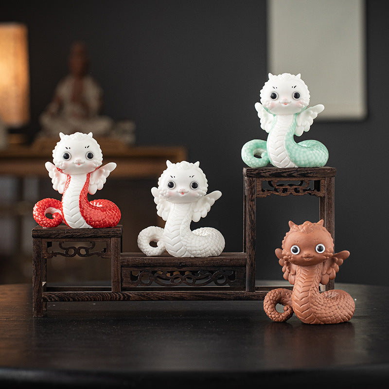 this is a white ceramic snake tea pet