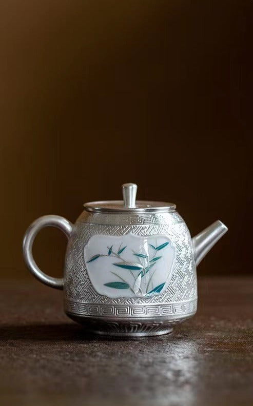 This is a gilted silver ceramic teapot