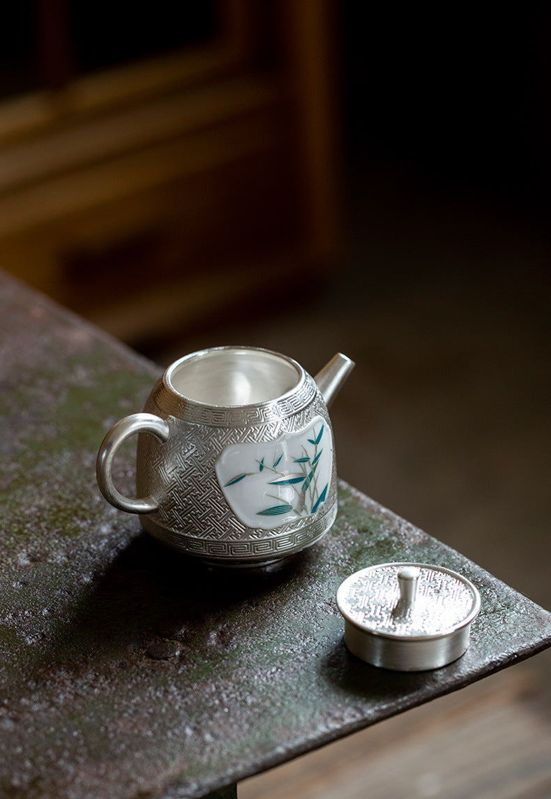 This is a gilted silver ceramic teapot