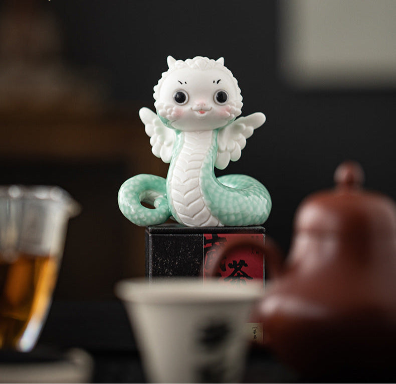 this is a white ceramic snake tea pet