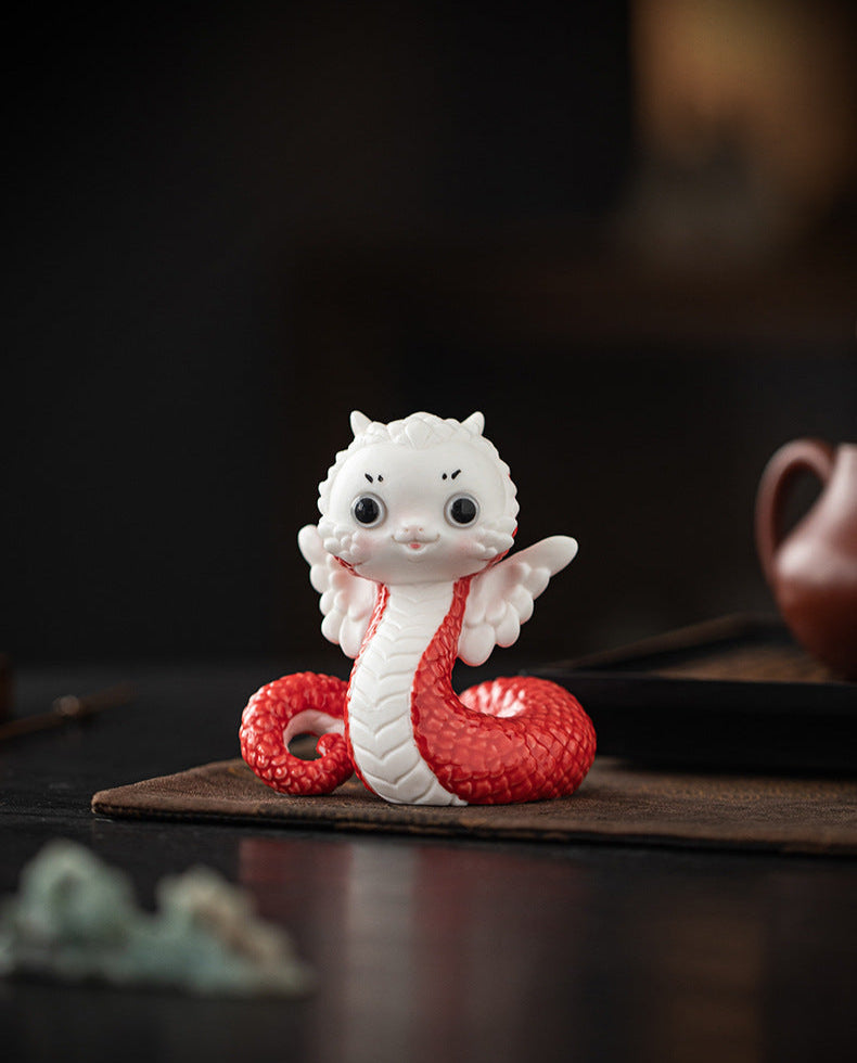 this is a white ceramic snake tea pet