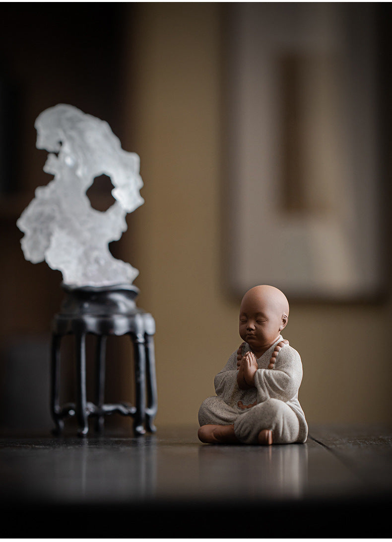 this is a mini pottery monk sculpture