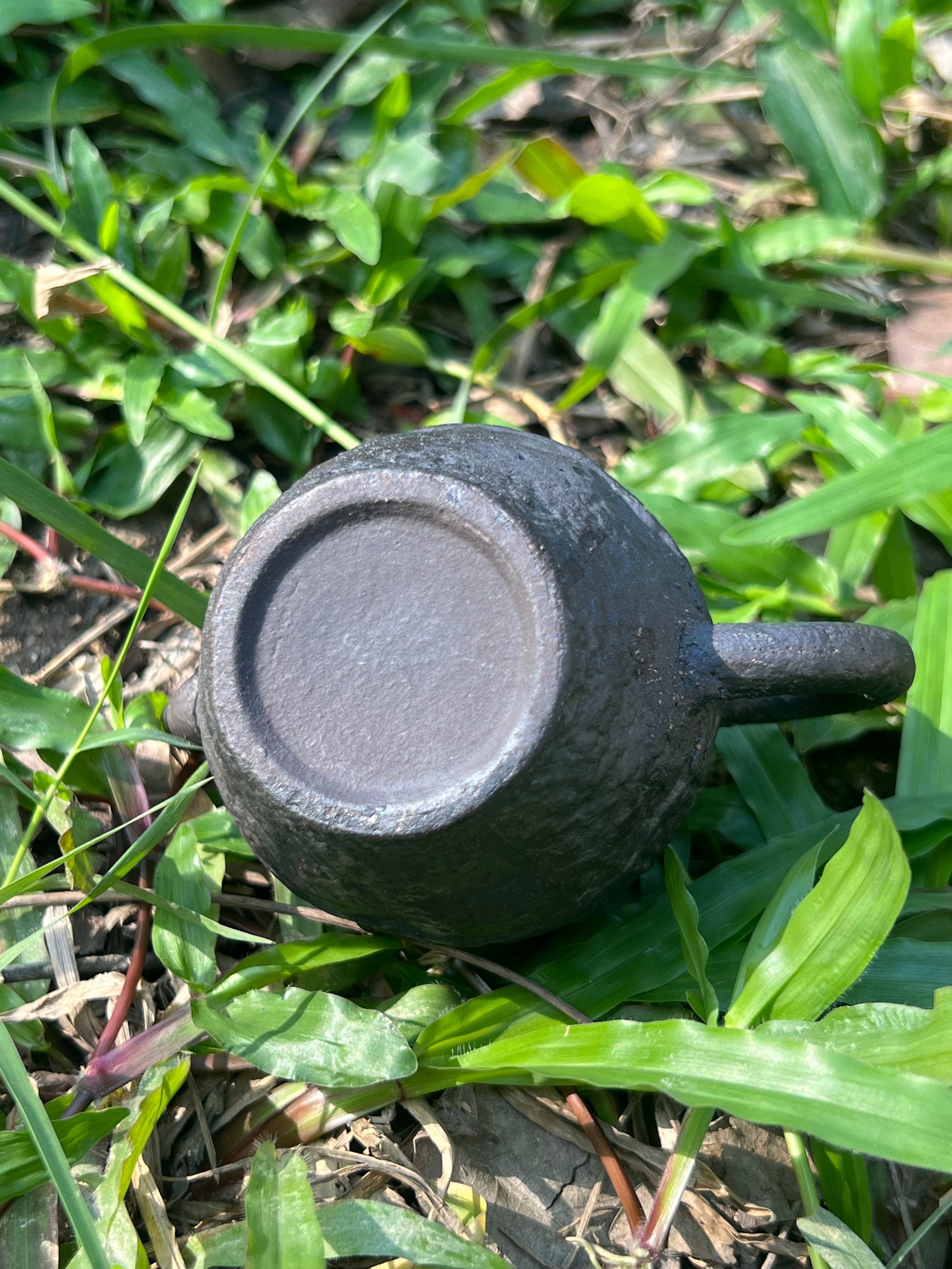 this is a pottery teapot. this is a purple clay teapot